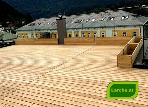 Dachterrasse aus Lärchenholz mit Blumenkisten und Ausblick aufs Nachbarshaus