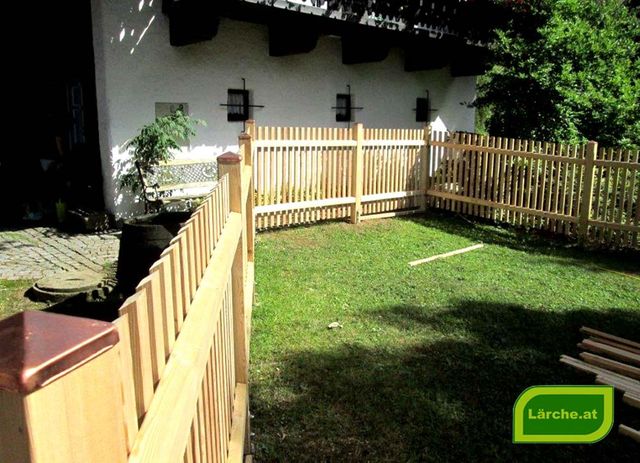 schräger Lärchenzaun im Garten neben einem Haus